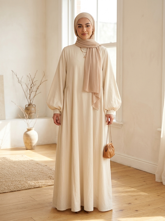 Woman in cream maxi dress in bright airy room